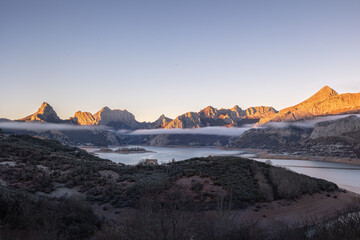 Icy dawn. The warm sky contrasts with the cold emanating from the meadow, covered in frost.