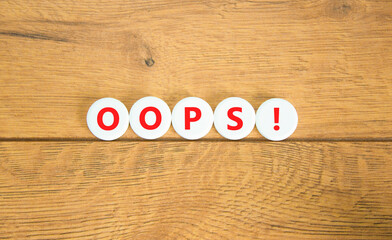 Oops symbol. Concept word Oops on beautiful white circles. Beautiful wooden table wooden...