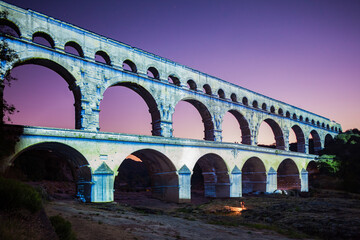 Pont du Gard, ancient Roman aqueduct bridge, colorful projection mapping video show, under Provence starry night sky, Gorges du Gardon, natural landscape designated Biosphere Reserve by UNESCO, France