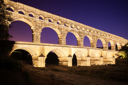 Pont du Gard, ancient Roman aqueduct bridge, colorful projection mapping video show, under Provence starry night sky, Gorges du Gardon, natural landscape designated Biosphere Reserve by UNESCO, France