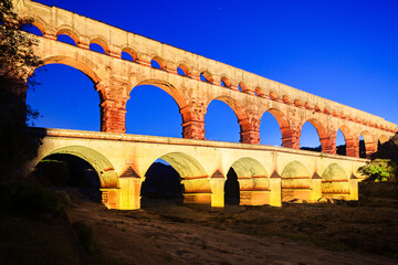 Pont du Gard, ancient Roman aqueduct bridge, colorful projection mapping video show, under Provence starry night sky, Gorges du Gardon, natural landscape designated Biosphere Reserve by UNESCO, France
