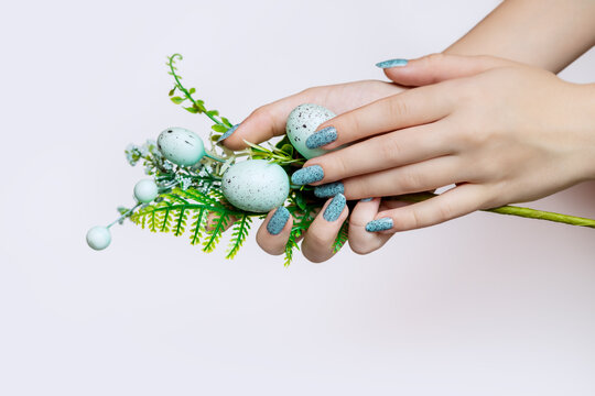 Beautiful Easter manicure for a young woman. Decorative Easter eggs for holiday decoration. 