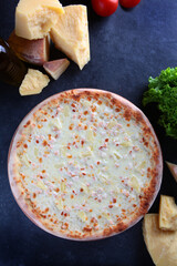 Pizza with pineapple and smoked chicken. White sauce. An exquisite pizza filling. Flat lay. Top view.