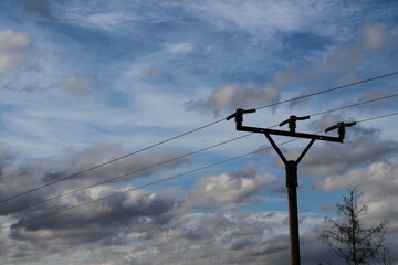 Electrical pole with electrical cables on a beautiful blue sky background
