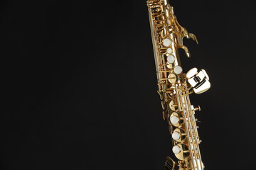 Jazz. One beautiful saxophone on black background, closeup. Space for text