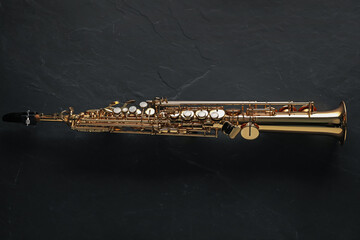 Jazz. One saxophone on black table, top view