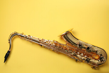 Jazz. One saxophone on yellow background, top view