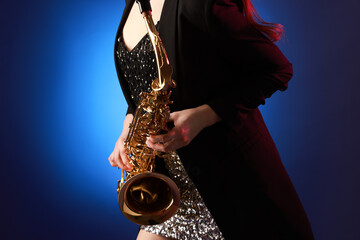 Professional musician with saxophone on color background, closeup