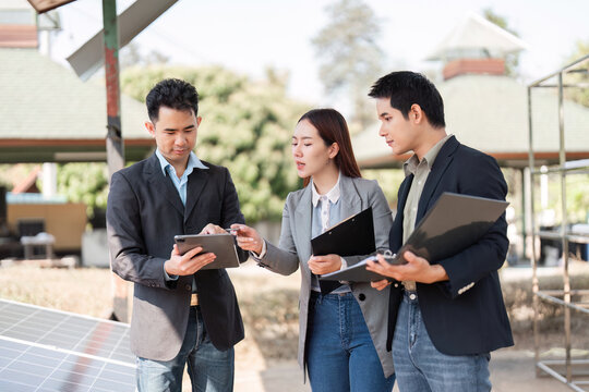 Sustainable business initiative. Professionals analyzing solar energy data outdoors. - Powered by Adobe