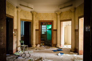 L'atrio di un padiglione dell'ospedale abbandonato del Lido di Venezia con tre porte e materiale abbandonato sul pavimento