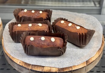 Indulge in Delicious Chocolate Treats, Beautifully Finished with a Creamy Topping. Indulgent and tempting chocolate desserts are elegantly arranged and beautifully displayed on a wooden platter