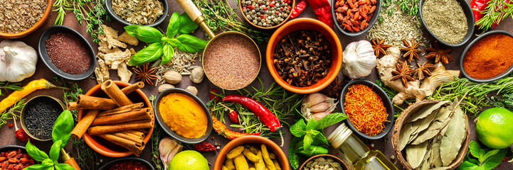 A visually striking arrangement of fresh spices and herbs on a brown surface, highlighting their...