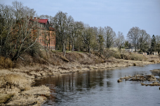 old building on river bank. Skaistkalne village, river Memele, school building, Latvia
