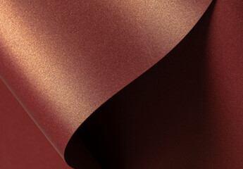 Burgundy paper background with a glossy, pearlescent texture and shimmering metallic finish. Rich...