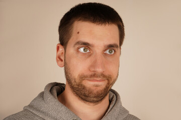 Obraz premium His facial features are tense, clearly expressing his aversion or repulsion to something he finds unpleasant. In this close-up, a young man s face displays a disgusted expression, with his eyes closed