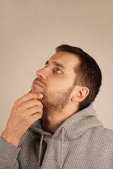 Obraz premium His serious expression reflects a moment of deep thought. The gesture suggests focus and introspection. A man thoughtfully rests his hand on his chin, appearing deep in contemplation.