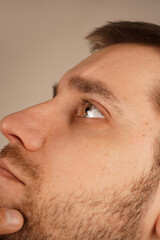 A man thoughtfully rests his hand on his chin, appearing deep in contemplation. His serious...