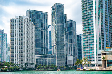 Fototapeta premium Urban Skyline: Capturing the soaring essence of city living with imposing high-rise buildings standing tall against a sky backdrop over the water