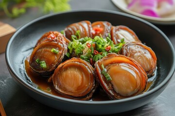 Braised dried abalone with oyster sauce on a plate viewed from above