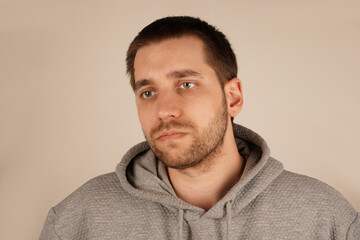 Obraz premium A close-up of the face of a man with dark hair and a slightly stubbled chin. His natural expression conveys a slight displeasure or pain. The focus emphasizes the fine texture of his skin.