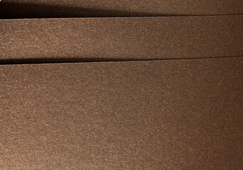 Fototapeta premium Brown paper background with a grainy texture and subtle shimmering finish. Rich, warm tones and geometric lines create an elegant, luxurious, and premium design, perfect for artistic stationery and.