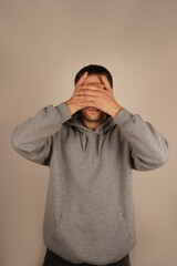 His gesture shows a clear rejection of the situation, signaling discomfort. A man covers his eyes...