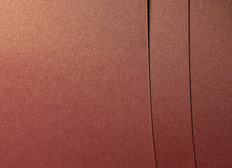 Fototapeta premium Rich burgundy paper texture with a pearlescent shimmer and glossy finish. Elegant and metallic reflective surface, perfect for luxury design and premium decorative backgrounds..