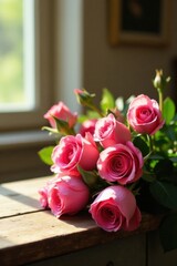 Obraz premium A delicate bouquet of pink roses rests on a weathered wooden surface, bathed in the soft glow of sunlight streaming through a nearby window.