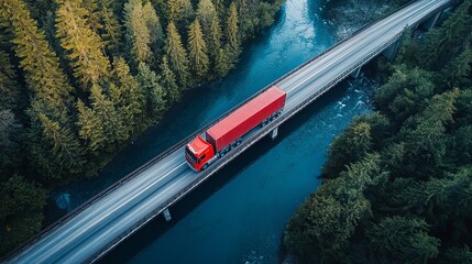 Transport truck drives across a bridge surrounded by dense green forests and a river under a clear blue sky