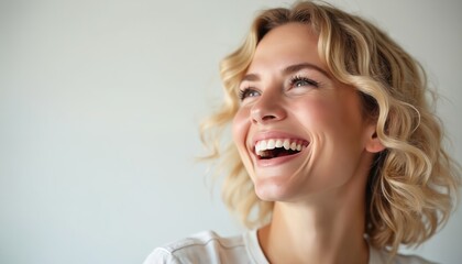 Naklejka premium Beauty portrait of laughing blond woman. Smile reveals perfect white teeth. Clean fresh face on white background. Healthy skin and wellness concept. Cosmetology and dental care ad.