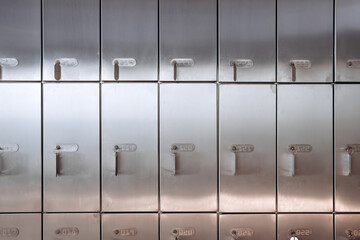 A close-up shot of a row of metal safe deposit boxes, showcasing their locks and numbered labels