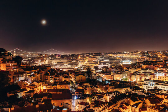 A beautiful nighttime panoramic view of Lisbon from a hilltop viewpoint, showcasing the illuminated cityscape - Powered by Adobe
