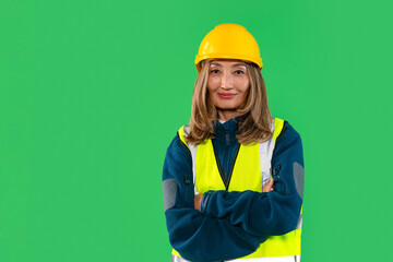 Construction worker poses confidently wearing yellow hard hat and safety vest against bright green background showcasing professionalism and readiness