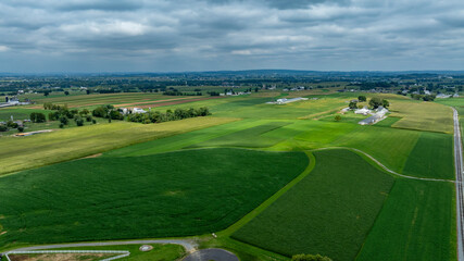 Obraz premium Expansive Green Farmland Under a Cloudy Sky Captured During Late Afternoon Near Rural Landscape