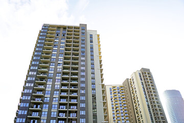 Obraz premium Modern urban development: apartment buildings and an office high-rise photographed from the bottom up. Construction in Serbia: cityscape from the Waterfront district in ​​Belgrade