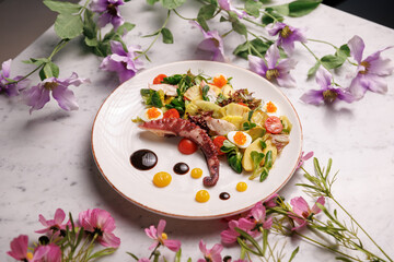 Seafood dish with octopus tentacle served in a restaurant with creative presentation. Premium gourmet