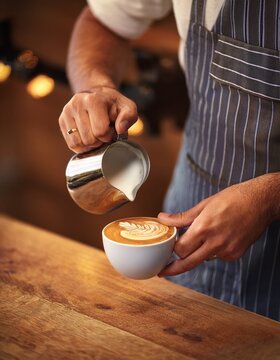 Un barista prepara un delicioso caf&eacute; con leche en la cafeter&iacute;a