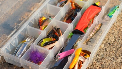Angler tackle box with artificial fishing gear on the rock surface. Accessories for fishing...