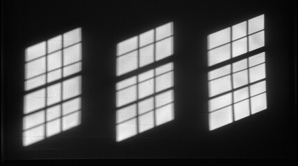 A black and white image of three windows with white frames.