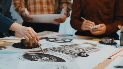 Fototapeta premium Engineers engage in a dynamic discussion over intricate technical drawings in a collaborative workspace, illustrating creativity and teamwork in project development. SACTR