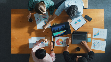 Top down view of smart business people hand working together to analyze chart. Skilled marketing team discussing about financial plan at table with stock market exchange report placed. Convocation.
