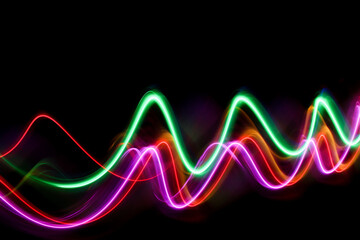 A long exposure photograph of colourful lights in swirl patterns of motion against a black background