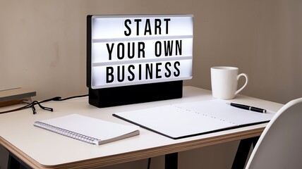 Start your own business inspiration, glowing lightbox with motivational words, minimalistic office desk with stationery