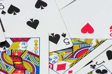 Scattered collection of playing cards, featuring various suits, numbers, and partial card faces. Chaotic arrangement creates a dynamic scene, symbolizing the unpredictability and thrill of card games