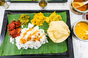 Banana Leaf Rice, Indian Street Food, Southern India dish. White steamed rice served with few types of vegetables and sauces, served on top of banana leaf as the plate.