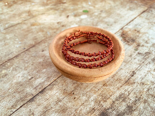 handmade wire copper bracelet on wooden table