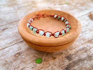 handmade wire copper bracelet on wooden table