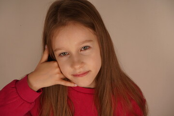 A cute and fun moment of childlike creativity. The little girl holds her hand to her ear, pretending to make a phone call. Her playful expression shows she's fully immersed in the imaginative game.
