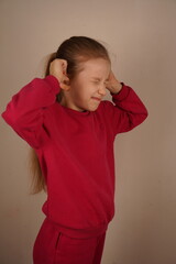 Her expression shows discomfort and a desire to block out unwanted noise. It s a moment of...