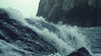 Fototapeta premium Wild Ocean Waves Crashing Against Rocky Shore Under Cloudy Sky